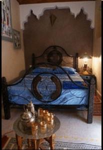 a bedroom with a blue bed and a table at Riad Tarik in Marrakesh