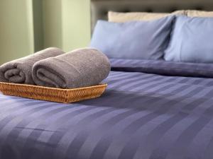 a basket of towels sitting on top of a bed at Baansuay Rattanathibet Apartment in Nonthaburi