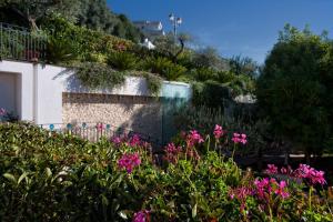 a garden with pink flowers in front of a building at Virgilio Grand Hotel in Sperlonga
