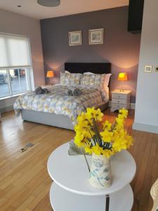 a bedroom with a bed and a table with flowers at Greenmile House, in Kilmeaden