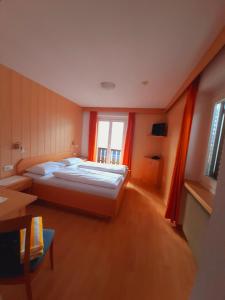 a large bedroom with a bed and a window at Hotel Pörnbacher in Valdaora
