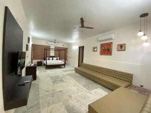 a living room with a couch and a television at Casa Blanca - A Boutique Resort in Ahmedabad