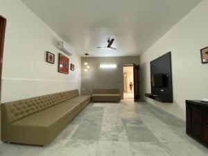 a living room with a couch and a tv at Casa Blanca - A Boutique Resort in Ahmedabad