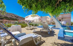 a group of chairs and an umbrella next to a swimming pool at Bed & Breakfast Valentina in Metajna