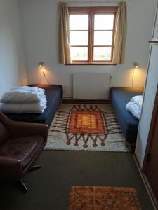 a room with two beds and a couch and a window at Store Lærkegård in Allinge