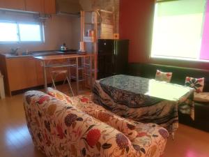 a living room with a couch and a table at Guest House Tomida in Ena