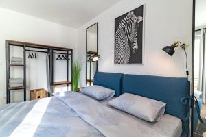 a bedroom with a blue bed and a zebra picture at INCANTO Apartment in Ruse