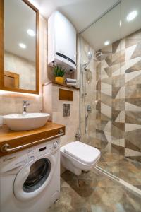 a bathroom with a washing machine and a sink at INCANTO Apartment in Ruse