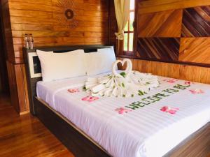 a bed with a swan on it with flowers on it at ไร่นาบัวหลวง คาเฟ่ & ฟาร์มสเตย์ RaiNa BuaLuang Cafe & Farm Stay in Ban Na No