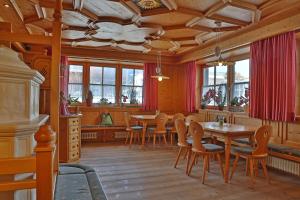 a dining room with a table and chairs at Hotel Pörnbacher in Valdaora