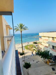 a view of the beach from the balcony of a building at A 2 passi dal mare! in Es Pujols