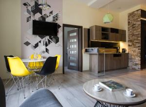 a living room with a table and yellow chairs at Yourplace M57 Apartments in Krakow
