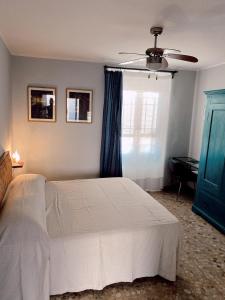 a bedroom with a white bed and a blue window at Atlante in Toscolano Maderno