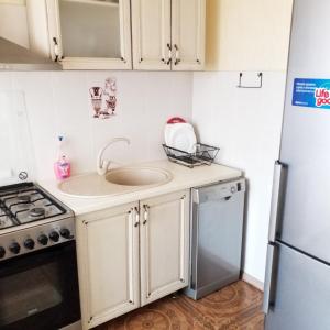 a small kitchen with a sink and a refrigerator at Дача в Санжейке с уютной территорией для отдыха у Чёрного моря in Sanzhiyka