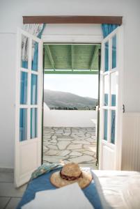 a bed with a hat sitting on top of it at Smaragdi - Naxian traditional house with panoramic view at Eggares village in Engares