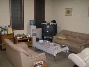 a living room with two couches and a tv at Ikawa Ryokan in Hiroshima