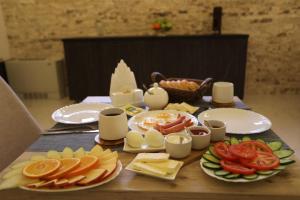 a table with plates of food and cheese and tomatoes at Hotel Rustaveli Kutaisi in Kutaisi