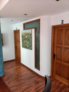 a room with a door and a chair and wooden floors at La Casona Canaria Boutique Home B & B in Agüimes