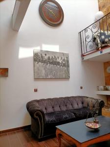 a living room with a brown couch and a table at La Casona Canaria Boutique Home B & B in Agüimes