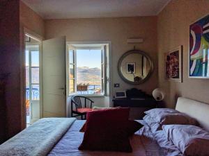 a bedroom with two beds and a mirror and a window at Ratto del Gallo in Stresa
