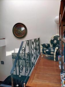 a staircase with a chair and a clock on the wall at La Casona Canaria Boutique Home B & B in Agüimes