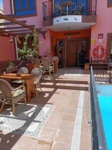 a patio with a table and chairs next to a pool at La Casona Canaria Boutique Home B & B in Agüimes