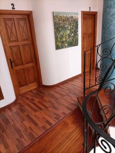 a hallway with two wooden doors and a painting at La Casona Canaria Boutique Home B & B in Agüimes