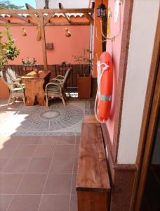 a wooden bench on a patio with a table and chairs at La Casona Canaria Boutique Home B & B in Agüimes