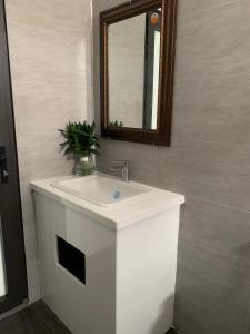 a bathroom with a white sink and a mirror at Khách sạn ĐẢO LÝ SƠN- AN DUYÊN in Quang Ngai