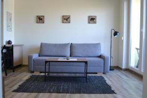 a living room with a blue couch and a table at Apartman Alisa in Veliko Gradište