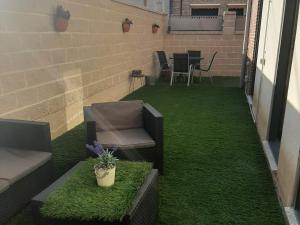 un patio con césped, una silla y una mesa en Arroyo, en Coreses