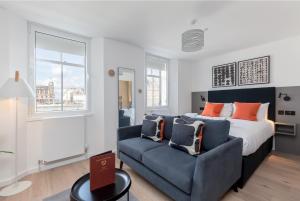 a bedroom with a bed and a couch at Destiny Scotland Market Street Apartments in Edinburgh