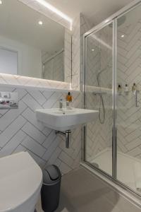a white bathroom with a sink and a shower at Destiny Scotland Market Street Apartments in Edinburgh +46 photos