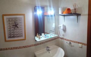 une salle de bain avec un lavabo et un miroir dans l'établissement Villa Sharon & Relax, à Corralejo 24 autres photos