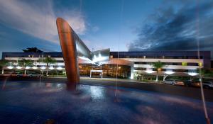 un grande edificio con un edificio con una piscina di fronte di Viale Cataratas Hotel & Eventos a Foz do Iguaçu