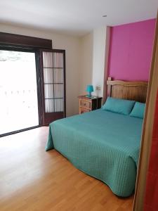 a bedroom with a green bed and a purple wall at Entrecuevas in Setenil