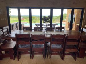 a dining room with a wooden table and chairs at Euphoria Self Catering Home in Naboomspruit