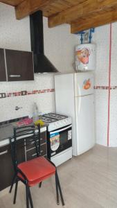een keuken met een fornuis en een witte koelkast bij MALARGUE STYLE,A 100 Mtrs DEL CENTRO,MUY UBICADO in Malargüe
