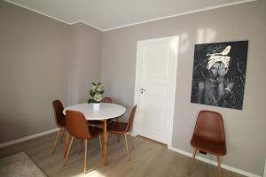une salle à manger avec une table et des chaises blanches dans l'établissement Krsferie leiligheter ved sentrum - Grim, à Kristiansand