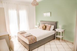 Schlafzimmer mit einem Bett mit weißer Bettwäsche und einem Fenster in der Unterkunft Filia Rooms & Apartments in Agio Apóstoloi