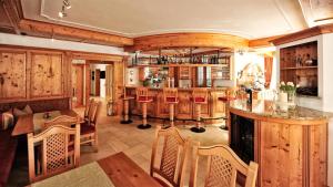 eine Küche mit Holzschränken und eine Bar mit Stühlen in der Unterkunft Alpenstern - Sommer Silvretta Card Premium inklusive! in Ischgl