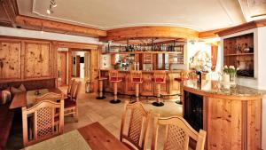 a kitchen with wooden cabinets and a bar with chairs at Alpenstern in Ischgl