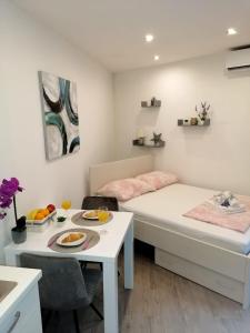 a small room with a bed and a table with a plate of fruit on it at Studio apartman Megy in Sutivan