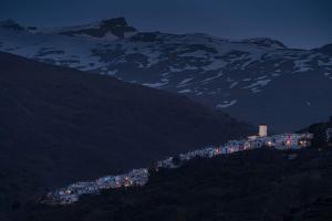 hostal ruta de las nieves في كابيليرا: مدينه فوق جبل في الليل