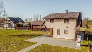 une maison blanche avec un toit marron dans l'établissement Dom nad Narwią, à Wyszki