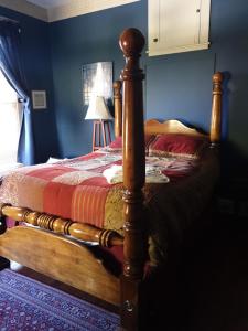 1 cama con marco de madera en un dormitorio en Ubon Thai Victorian Inn & Restaurant, en Staunton