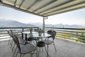 eine Terrasse mit Tischen und Stühlen auf einem Balkon mit Bergblick in der Unterkunft Hua Mu Xing Jing B&B in Renai