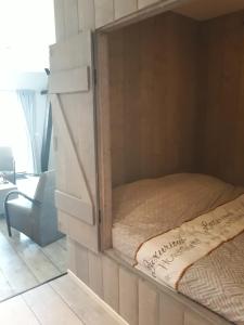a bedroom with a bed in a cabinet with a mirror at De Bedstee in Holwerd