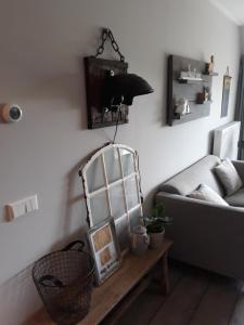 sala de estar con sofá y espejo sobre una mesa en De Bedstee, en Holwerd