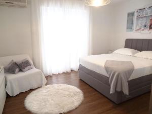 a bedroom with two beds and a rug and a window at Apartmani Igor in Makarska